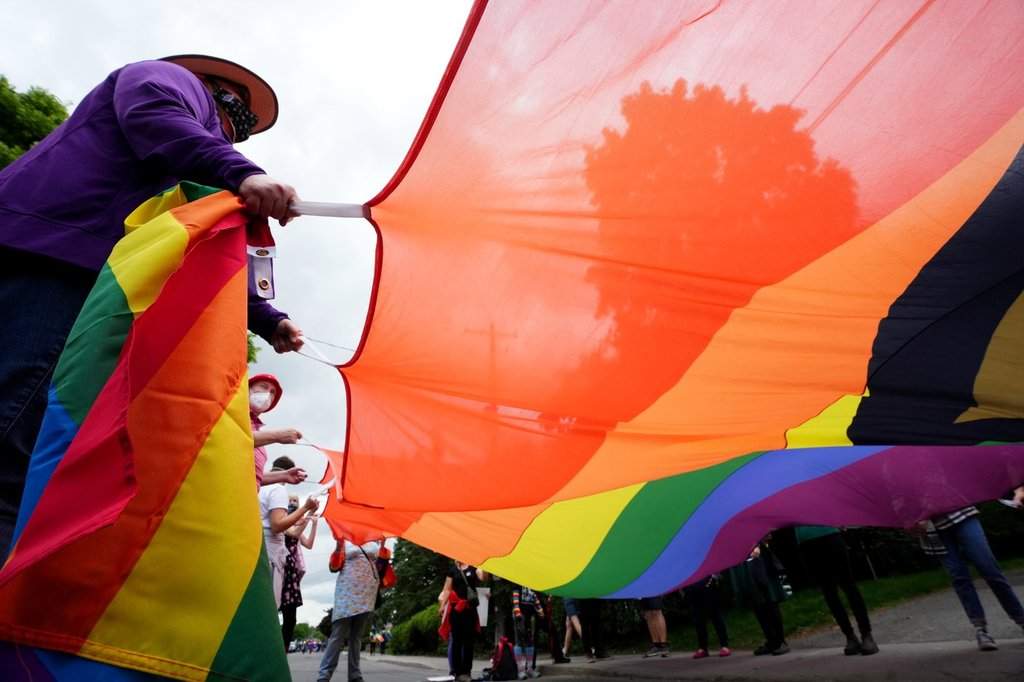 Counter protesters carry Pride and Trans Pride flags to confront a protest against Pride in Ottawa, Friday, June 9, 2023.