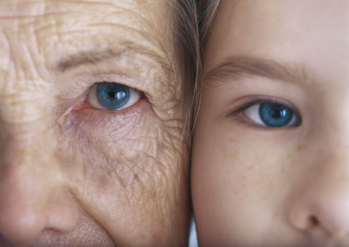 Girl and grandmother, cheek to cheek, close-up, partial view