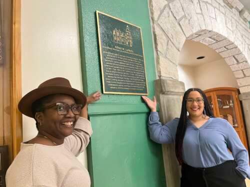 Marsha Hinds Myrie (left) and Natalie Brown (right) pictured with a plaque of Alfred M. Lafferty, Ontario's first Black principal.