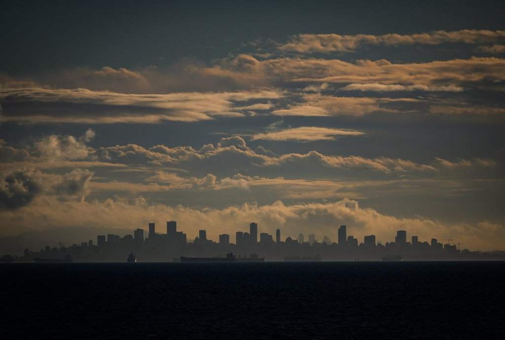 Cargo ships at anchor on English Bay and the downtown Vancouver, B.C., skyline are seen on October 16, 2024. THE CANADIAN PRESS/Darryl Dyck.