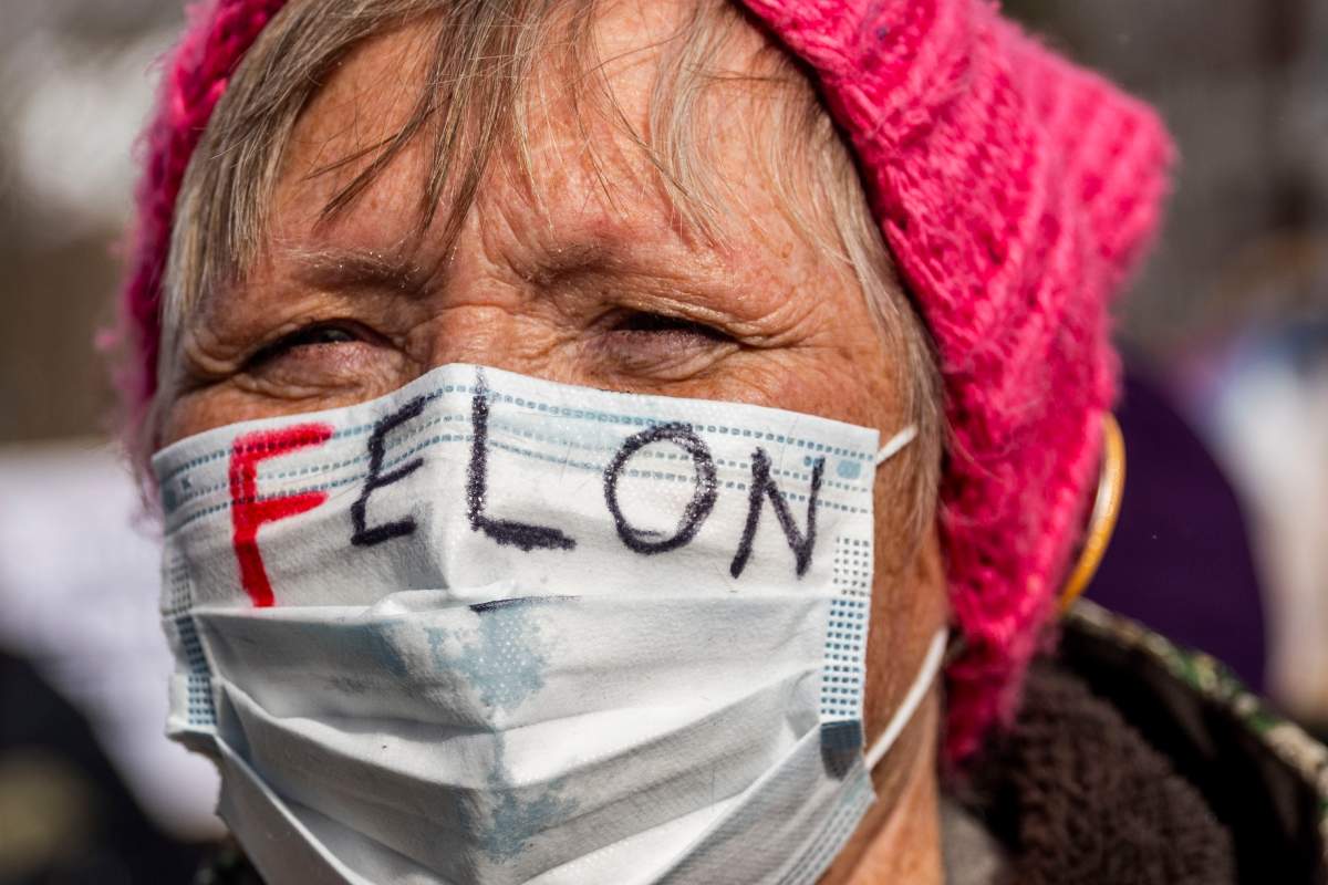 Kathy Wolfe, a 71-year-old Flint native, protests with hundreds of people gathered at the steps of Michigan's Capitol, Monday, Feb. 17, 2025 on Presidents' Day in Lansing, Mich.