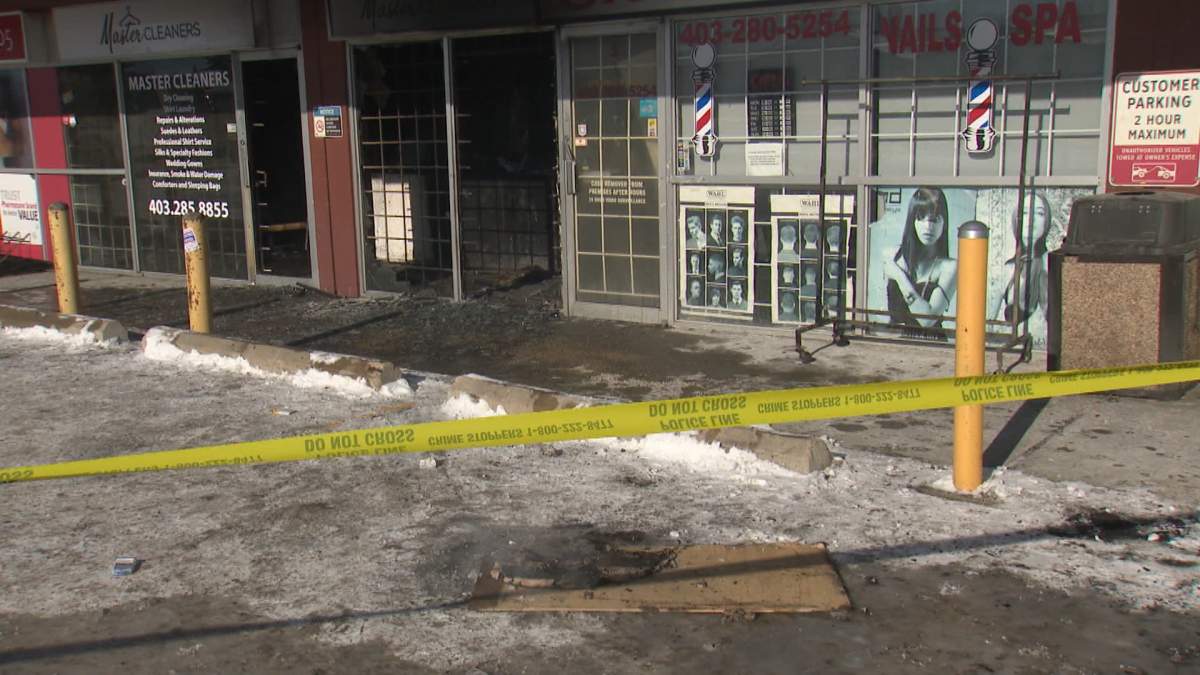 Police tape and a still-smouldering piece of wood located in front of a northeast Calgary business that was the scene of a suspicious fire early Monday morning.