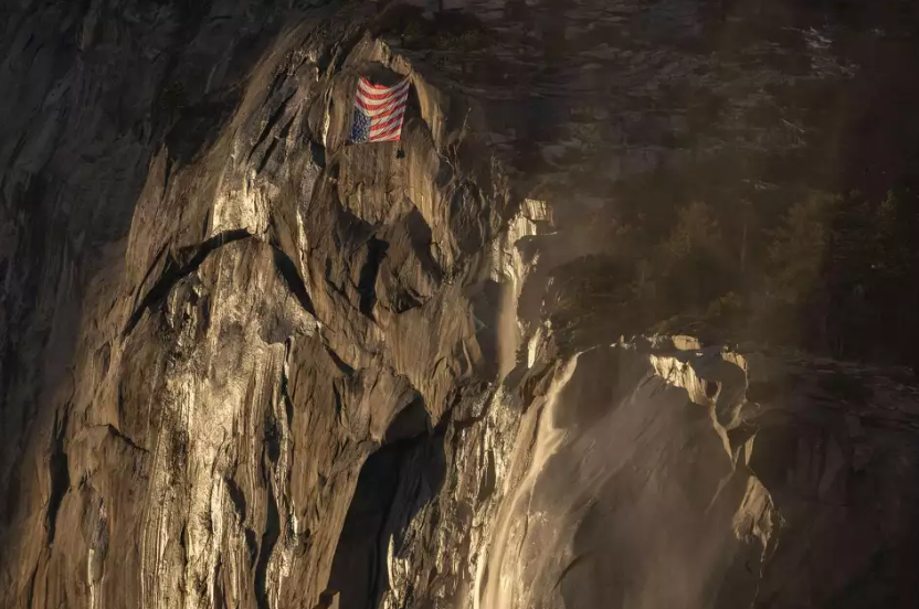 An upside-down American flag hangs at El Capitan in Yosemite National Park during the annual firefall on Saturday, Feb. 22, 2025.