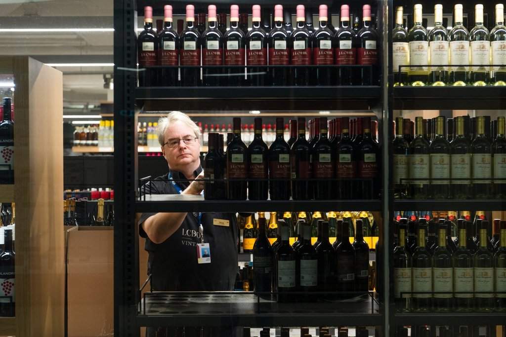 An LCBO employee moves products in an LCBO store at Union Station in Toronto on Tuesday, March 4, 2025.
