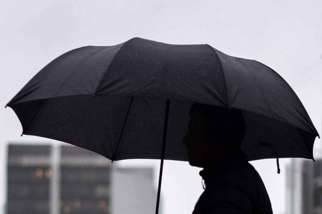 A person walks with an umbrella in this file photo.