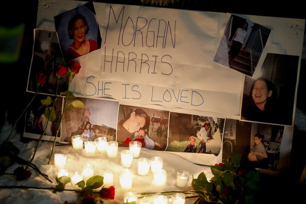 memorial with photos of Morgan Harris attached is shown as family and friends gather at a vigil in Winnipeg,