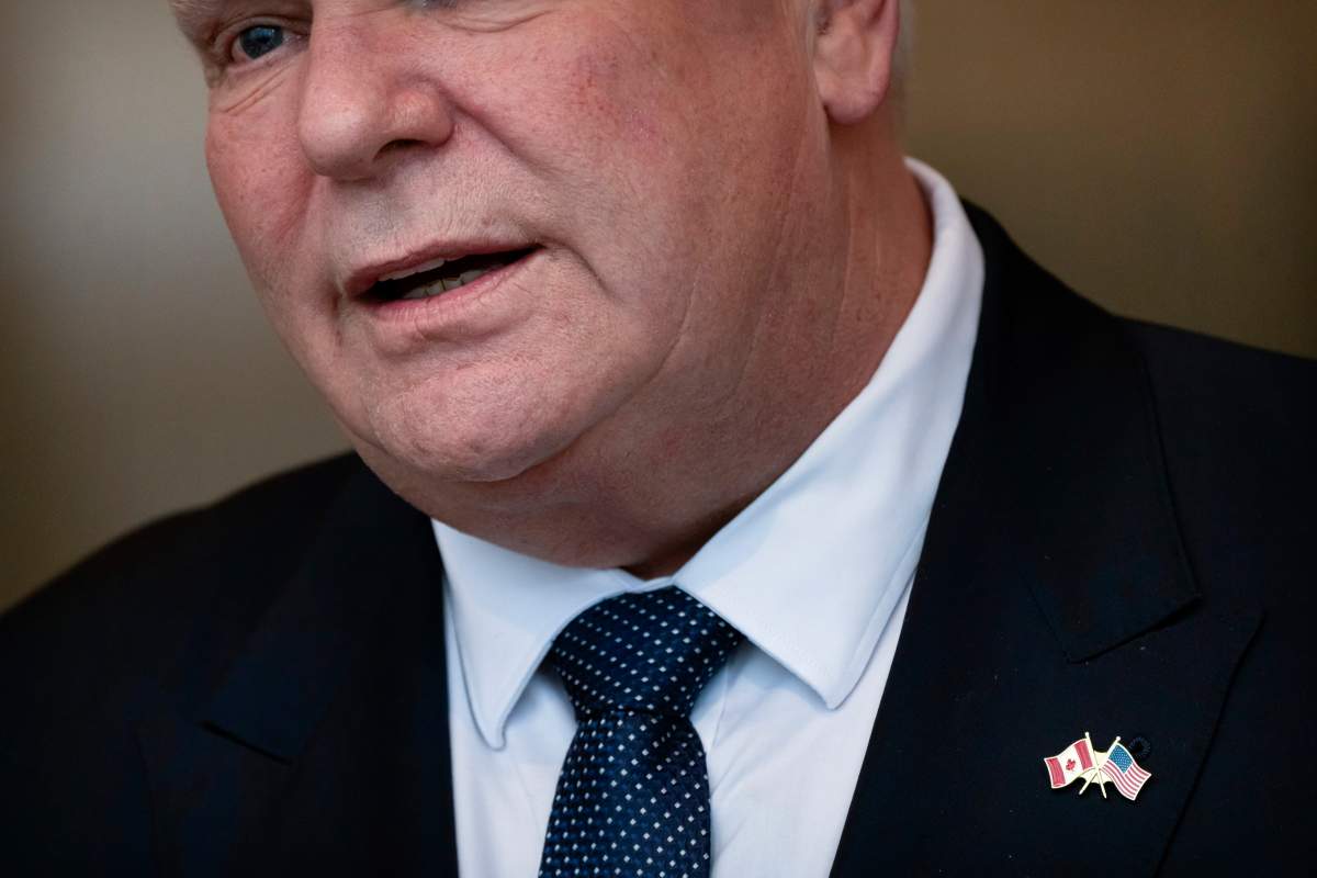 Ontario Premier Doug Ford wears a pin with the U.S. and Canadian flags as he speaks with reporters after an event with the U.S. Chamber of Commerce, Tuesday, Feb. 11, 2025, in Washington.