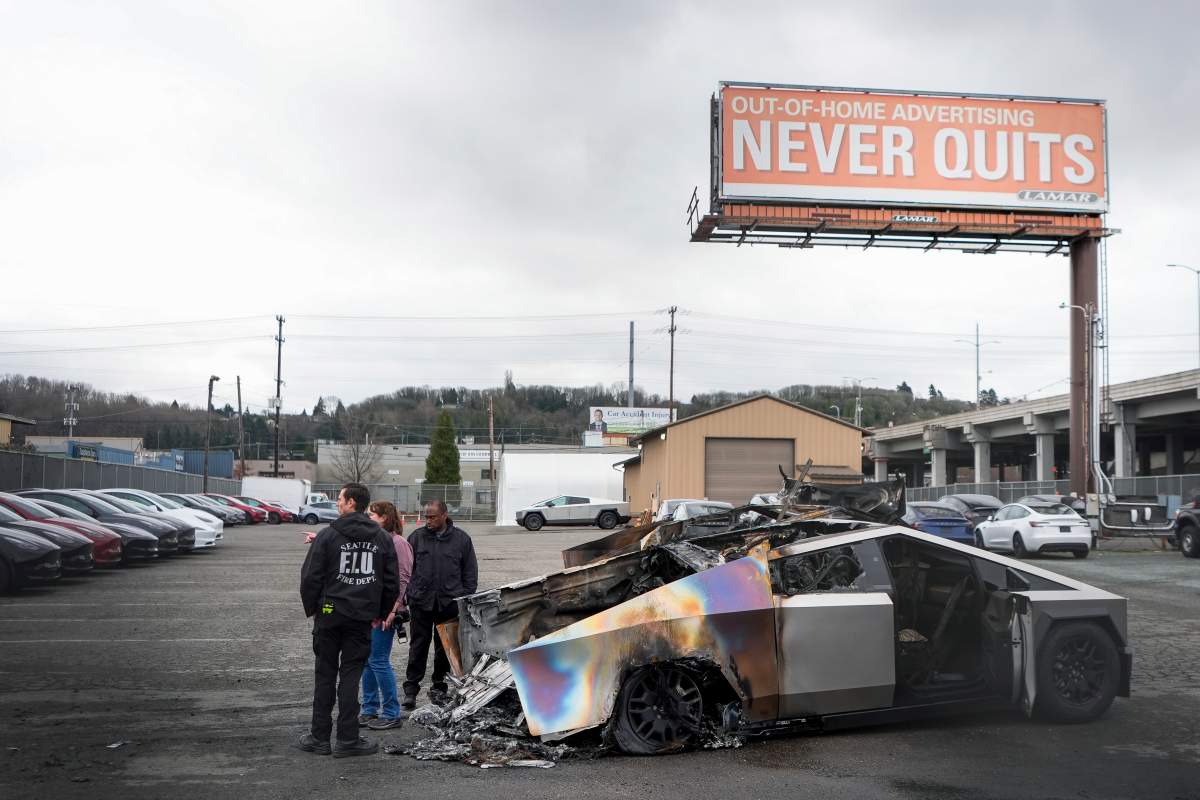 ATF investigators and a member of the Seattle Fire Department inspect burned Tesla Cybertrucks at a Tesla lot in Seattle, Monday, March 10, 2025.