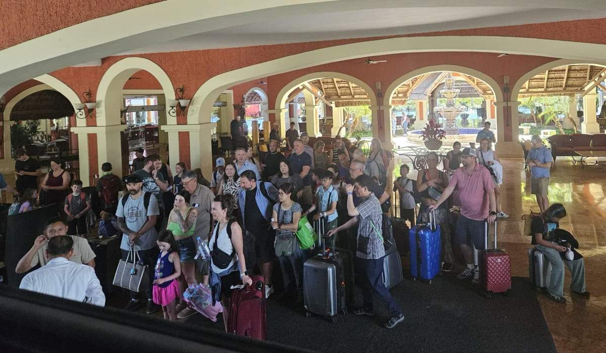 WestJet passengers waiting to be checked into a Barcello resort after their flight was delayed.