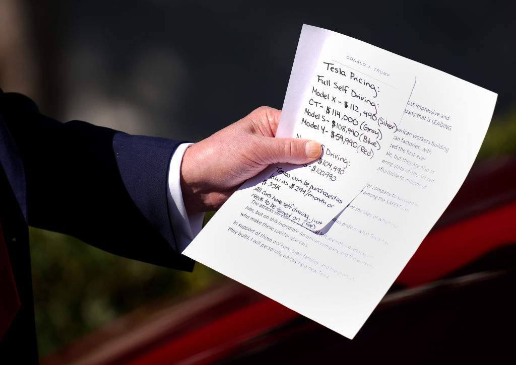President Donald Trump holds notes on the pricing of Tesla vehicles as he delivers remarks on the South Lawn of the White House on March 11, 2025 in Washington, DC. Trump spoke out against calls for a boycott of Elon Musk’s companies and said he would purchase a Tesla vehicle in what he calls a ‘show of confidence and support’ for Elon Musk. (Photo by Andrew Harnik/Getty Images)
