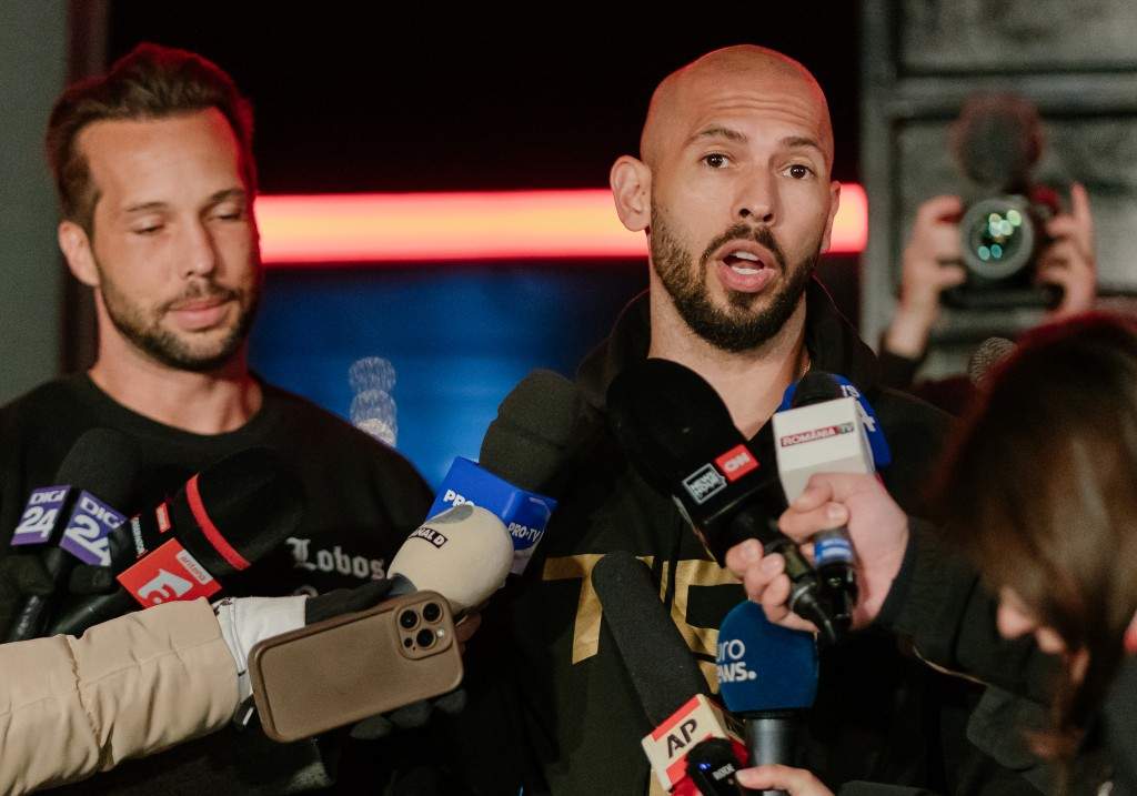 Andrew Tate and his brother Tristan Tate talk to the media outside their residence on March 23, 2025 in Bucharest, Romania.