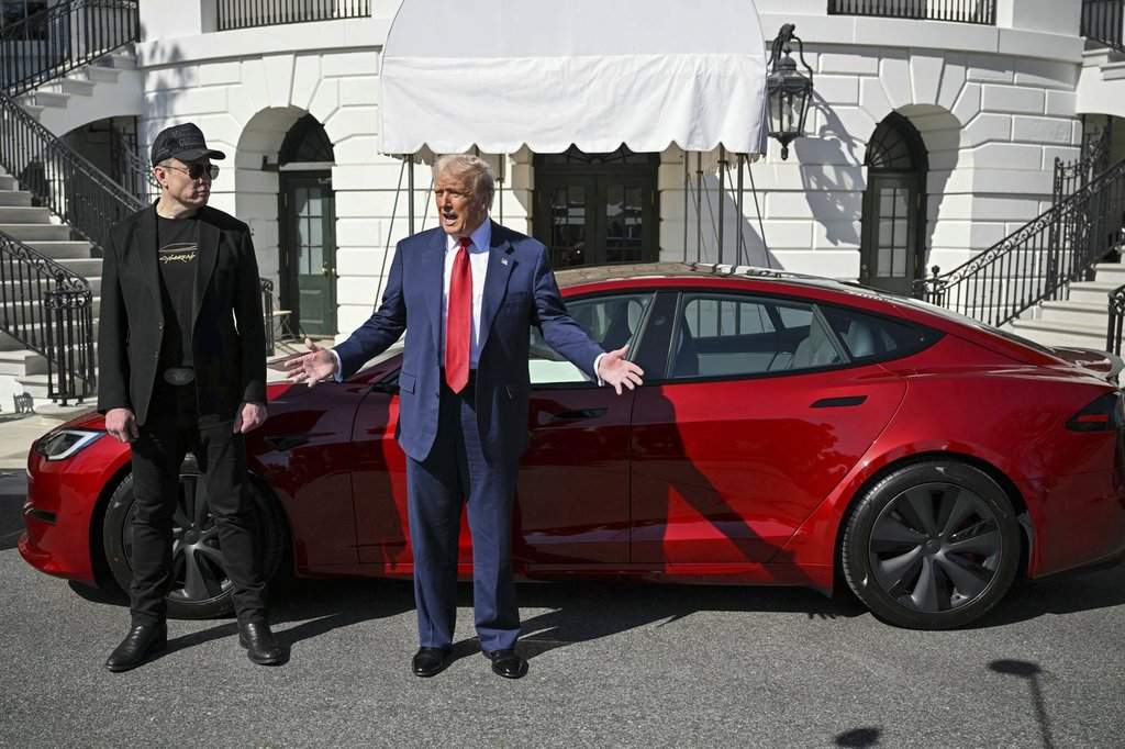 President Donald Trump and Tesla CEO Elon Musk speak to reporters near a red Model S Tesla vehicle on the South Lawn of the White House Tuesday, March 11, 2025, in Washington.