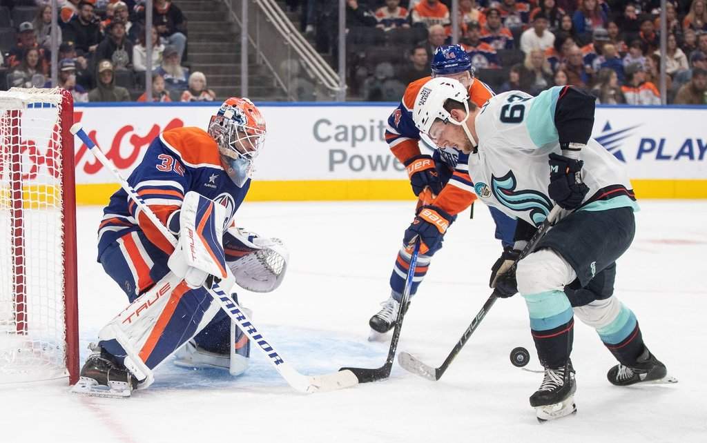 Seattle Kraken's Jacob Melanson (63) picks up the rebound from Edmonton Oilers goalie Olivier Rodrigue (35) during third period NHL pre-season action in Edmonton on Saturday September 28, 2024.