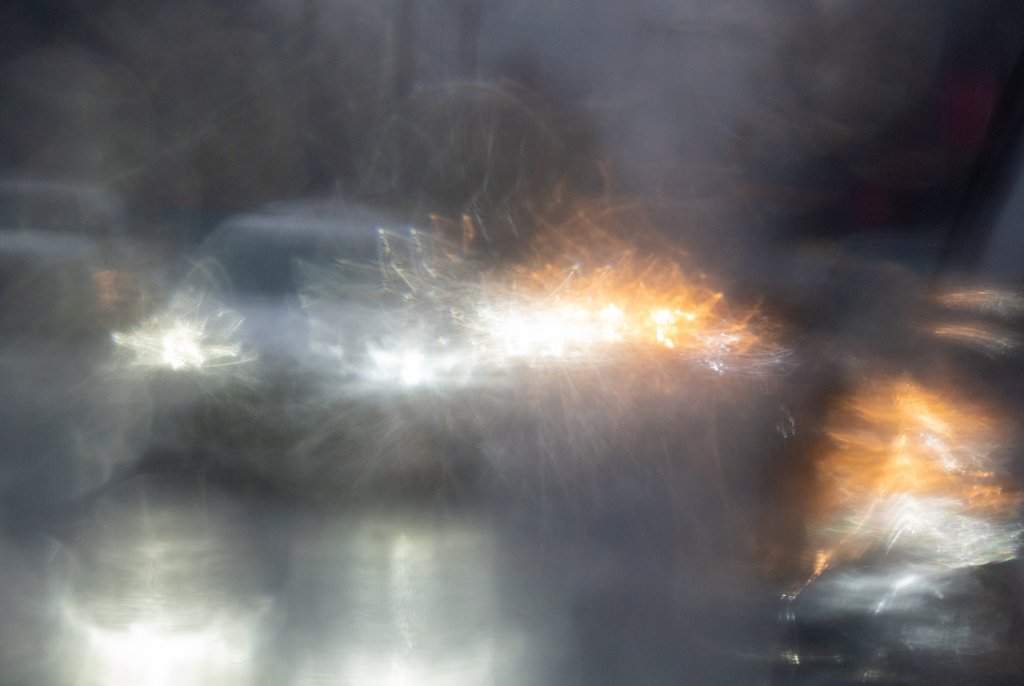 Traffic is reflected in a rain-covered car mirror as vehicles move through heavy rain in this file photo.