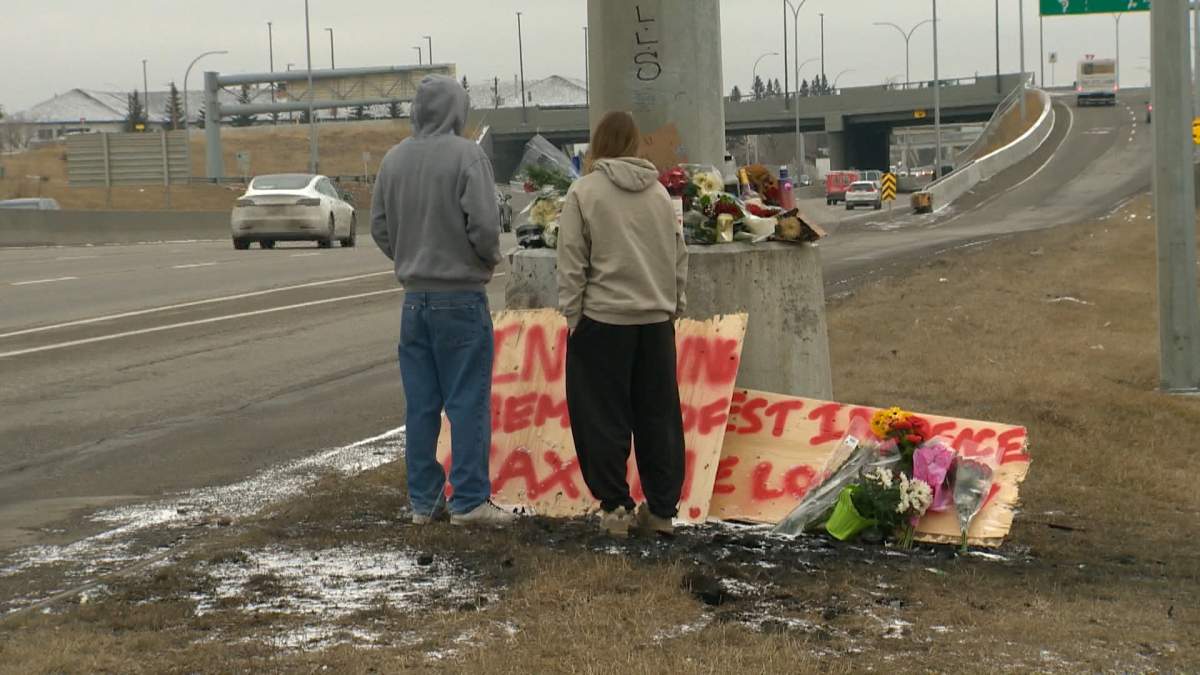 Friends pause to pay their respects at the memorial a 16-year-old boy killed in a crash on Crowchild Trail in Calgary on Wednesday.