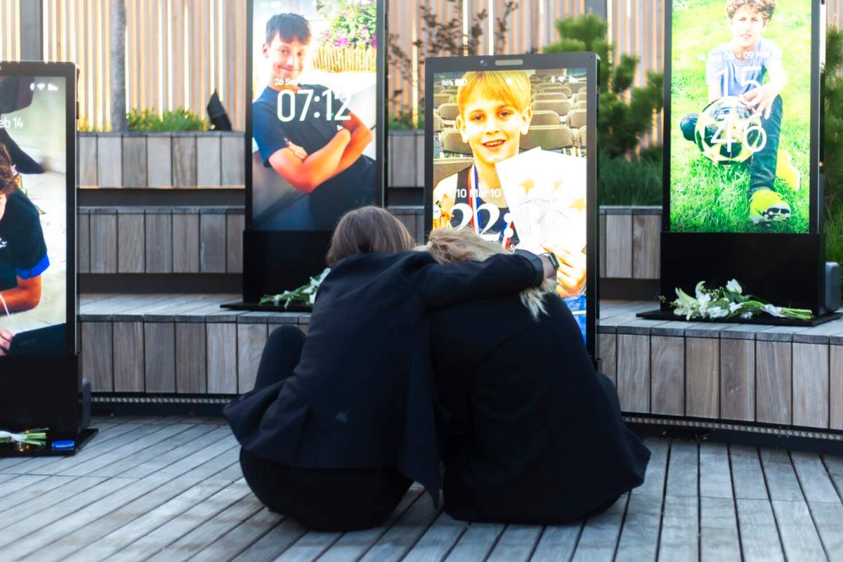 Visitors embrace at The Lock Screen Memorial in New York City.