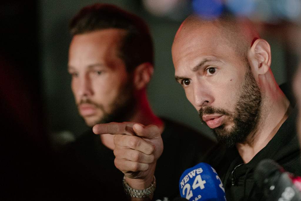 Andrew Tate and his brother Tristan Tate talk to the media outside their residence on March 23, 2025 in Bucharest, Romania. Andrew Tate and his brother Tristan had flown to the United States in February from Romania, where they have been charged with rape, having sex with a minor, human trafficking and money laundering, charges which they deny.
