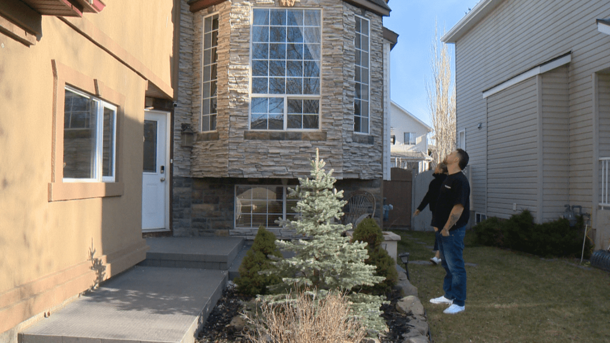 Calgary couple looks at the damage on their home.