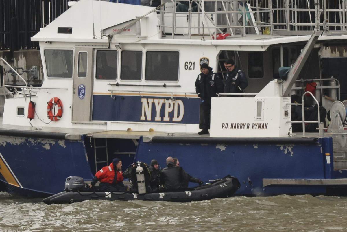 A New York Police Department scuba team prepares to dive, Friday, April 11, 2025, where a sightseeing helicopter crashed a day earlier into the Hudson River in Jersey City, N.J. (AP Photo/Yuki Iwamura)