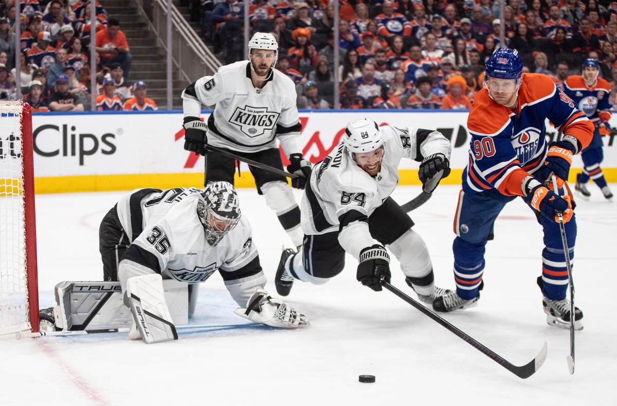 Los Angeles Kings goalie Darcy Kuemper (35) makes the save as Vladislav Gavrikov (84) and Edmonton Oilers' Corey Perry (90) reach for the rebound during second period NHL playoff action in Edmonton on Sunday, April 27, 2025.
