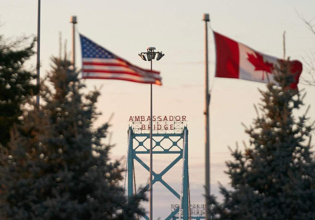 A file photo of Canadian and American flags fly on the Canadian side of the Ambassador Bridge in Windsor, Ontario, on March 8, 2025.