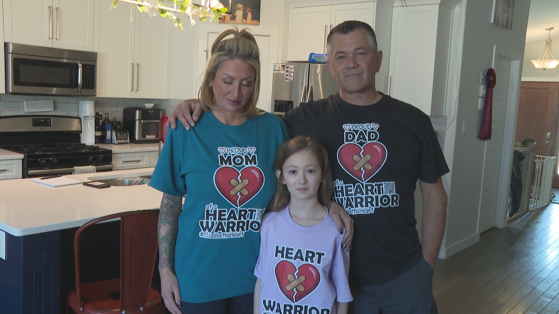 A woman, man, and young girl wearing heart warrior t-shirts.