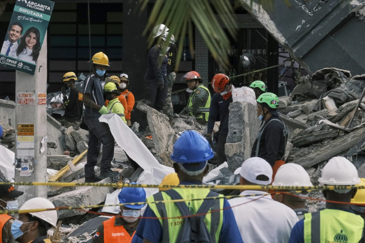 Rescue workers use sheets as they recover bodies from the rubble at the Jet Set nightclub after its roof collapsed two nights prior during a merengue concert in Santo Domingo, Dominican Republic, Wednesday, April 9, 2025.