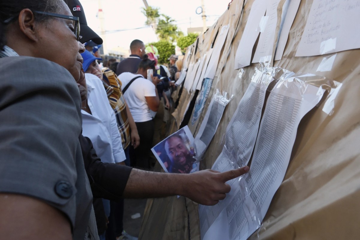 People searching for their missing relatives peruse a list of names outside the Jet Set nightclub after its roof collapsed during a merengue concert in Santo Domingo, Dominican Republic, Tuesday, April 8, 2025.