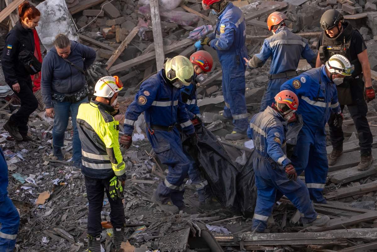 Rescue workers carry the body of a victim found under the rubble after a Russian strike in a residential neighborhood in Kyiv, Ukraine, Thursday, April 24, 2025. (AP Photo/Alex Babenko)