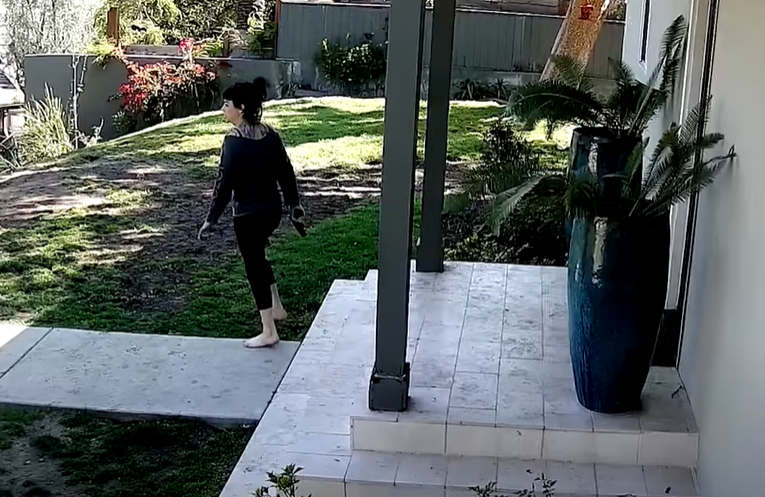 In a separate segment of silent surveillance video from Jillian Lauren’s backyard, Lauren can be seen exiting the home barefoot and carrying a pistol in her right hand.