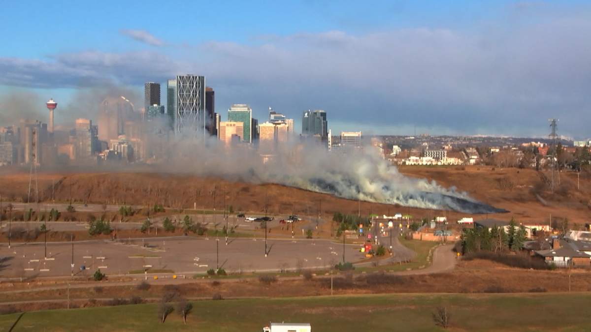 A large plume of smoke from a grass fire near the Calgary Zoo billows over the city skyline Thursday morning as fire crews scrambled to contain the blaze.