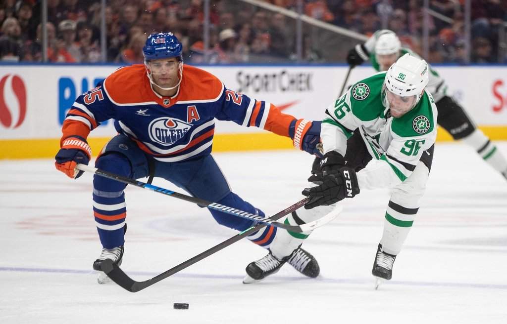Dallas Stars' Mikko Rantanen (96) and Edmonton Oilers' Darnell Nurse (25) battle for the puck during third period NHL action in Edmonton on Wednesday, March 26, 2025. The Stars and Oilers will meet in the NHL's Western Conference final series.