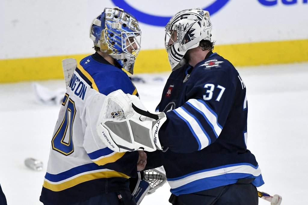 St. Louis Blues goaltender Jordan Binnington (50) shakes hands with Winnipeg Jets goaltender Connor Hellebuyck (37) after the Jets won in the second overtime period of NHL round one, game seven Stanley Cup playoff action in Winnipeg, Sunday May 4, 2025. THE CANADIAN PRESS/Fred Greenslade.
