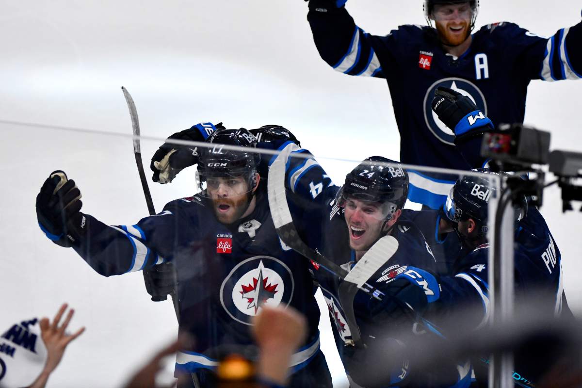 Winnipeg Jets’ Adam Lowry (17) celebrates his game-winning goal against the St. Louis Blues with Haydn Fleury (24) in the second overtime period of NHL round one, game seven Stanley Cup playoff action in Winnipeg, Sunday, May 4, 2025. THE CANADIAN PRESS/Fred Greenslade