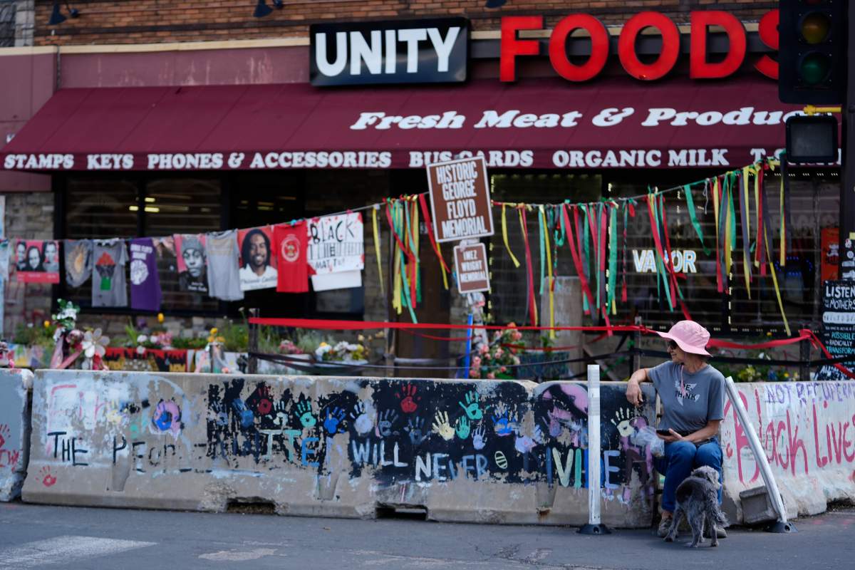 A woman with a dog visits the spot of George Floyd’s murder at George Floyd Square on the five-year anniversary of Floyd’s death, Sunday, May 25, 2025, in Minneapolis. (AP Photo/Abbie Parr)