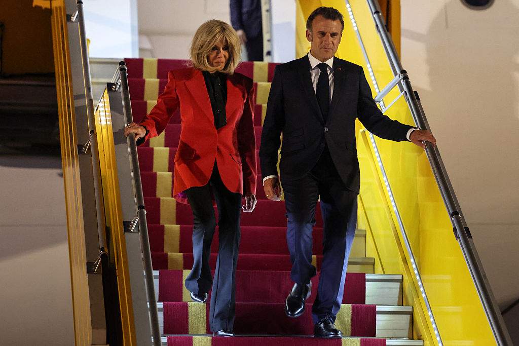 France's President Emmanuel Macron and his wife Brigitte Macron disembark from the plane upon their arrival at Noi Bai International Airport in Hanoi on May 25, 2025.