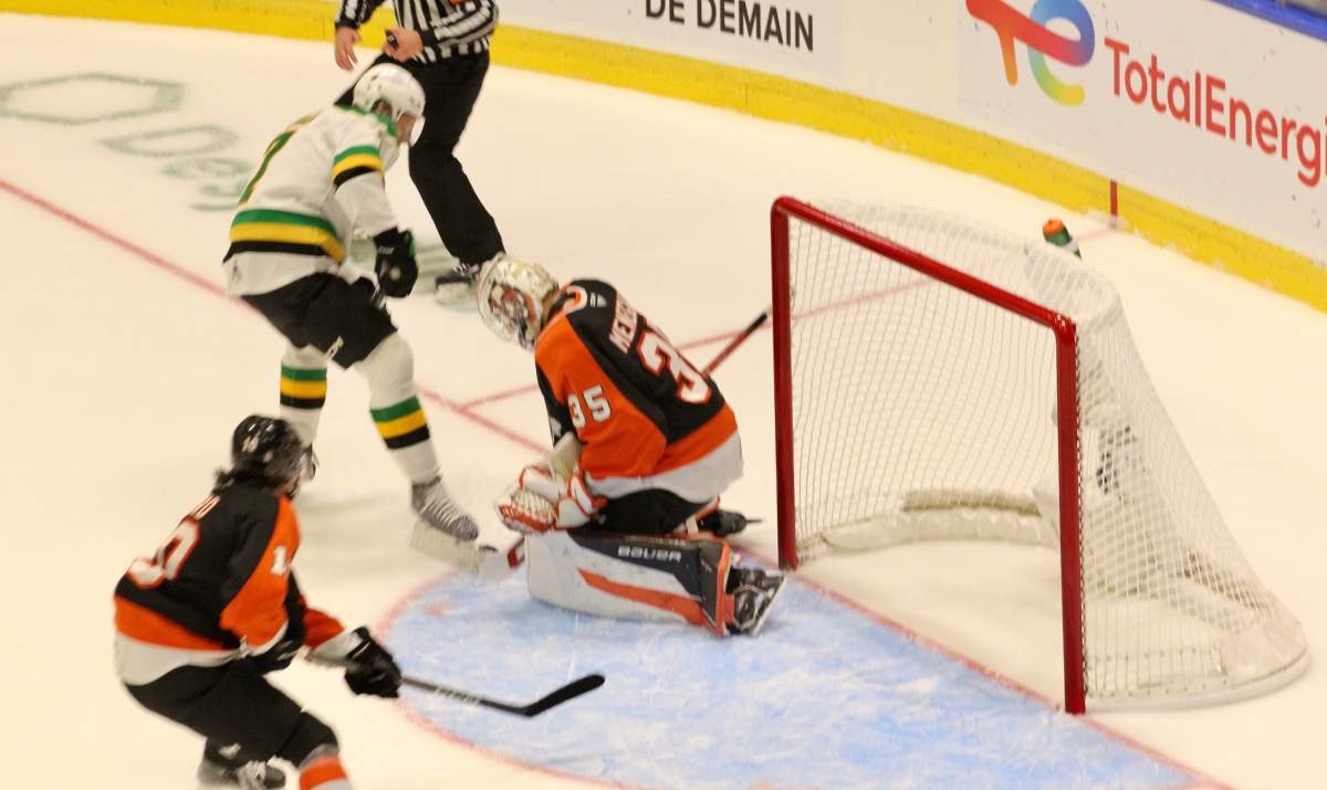 An Easton Cowan shot is stopped by Harrison Meneghin of Medicine Hat in the third period of a 2025 Memorial Cup round-robin game on May 27, 2025.