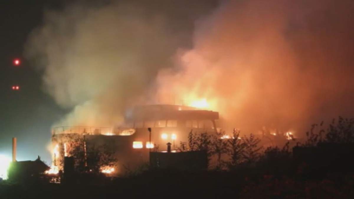 derelict ferry on fire bright flames in darkness