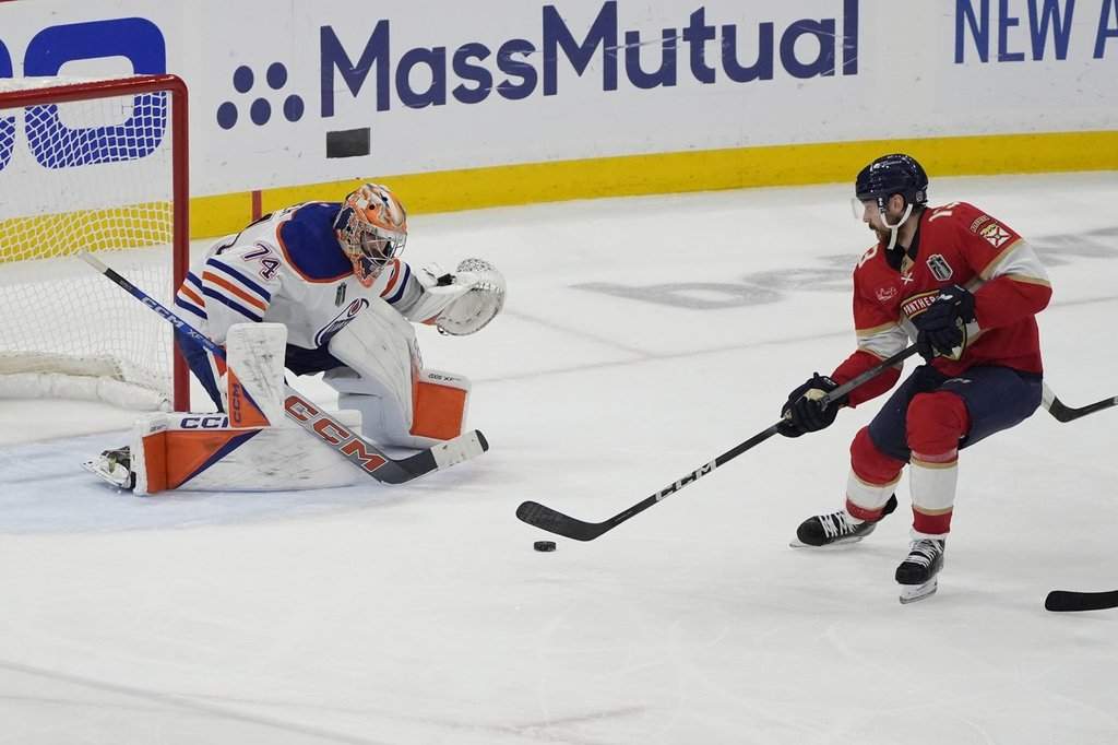 Edmonton Oilers goaltender Stuart Skinner (74) defends the net as Florida Panthers centre Sam Reinhart (13) makes a shot during the third period of Game 7 of the NHL hockey Stanley Cup Final, Monday, June 24, 2024, in Sunrise, Fla. The Panthers defeated the Oilers 2-1 to win the Stanley Cup.
