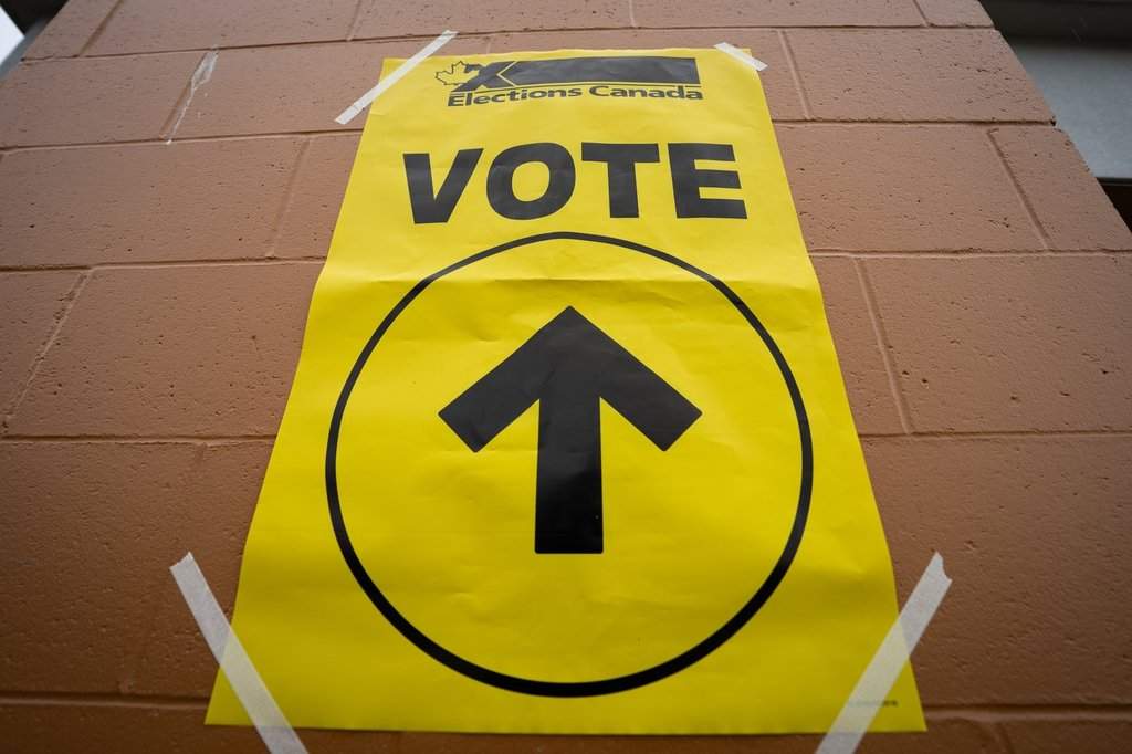 A vote sign is taped to the wall at a polling station on federal election day in Vancouver, on Monday, April 28, 2025. 