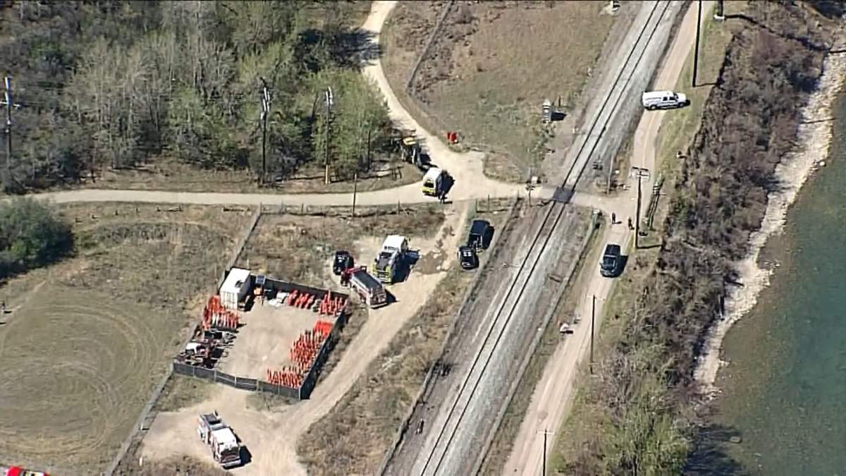 Fire fighters and police officers could be seen at this staging area west of Crowchild Trail on Monday morning after they were called in to assist in fighting a large brush fire near the railway tracks.
