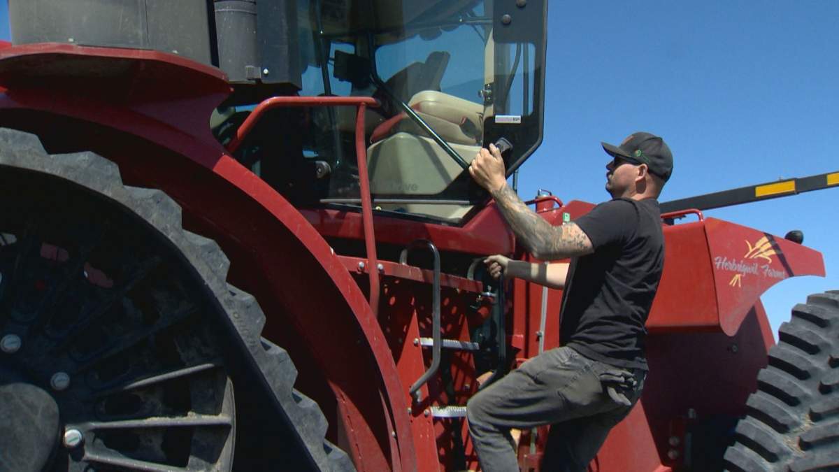 Korey Peters climbs into his tractor in one of his fields near Randolph, Man.