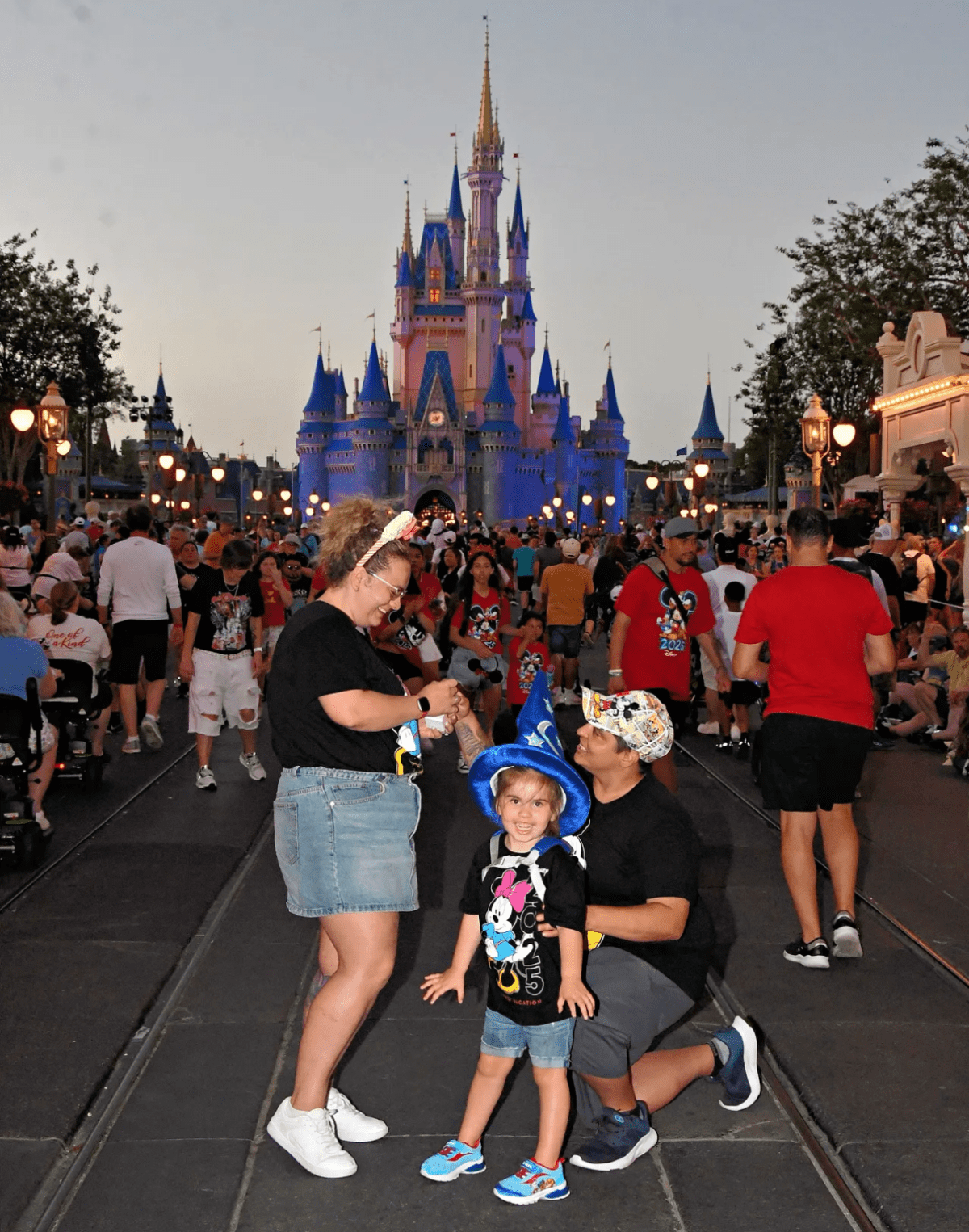 Miranda Sharp and her fiancé, Ashton Wilson, getting engaged at Disney World in the spring of 2025 while their daughter poses.