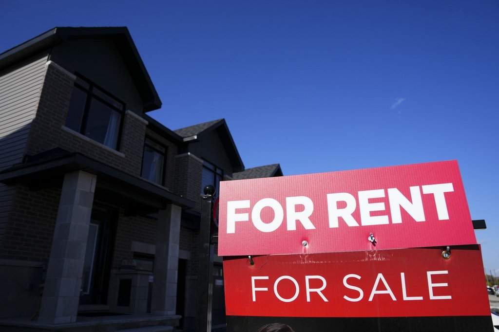 A for-rent and a for-sale sign are displayed on a house in a new housing development in Ottawa on Friday, Oct. 14, 2022. The national average asking rent in May was down 3.3 per cent from a year earlier at $2,129, marking the eighth consecutive month of year-over-year decreases.