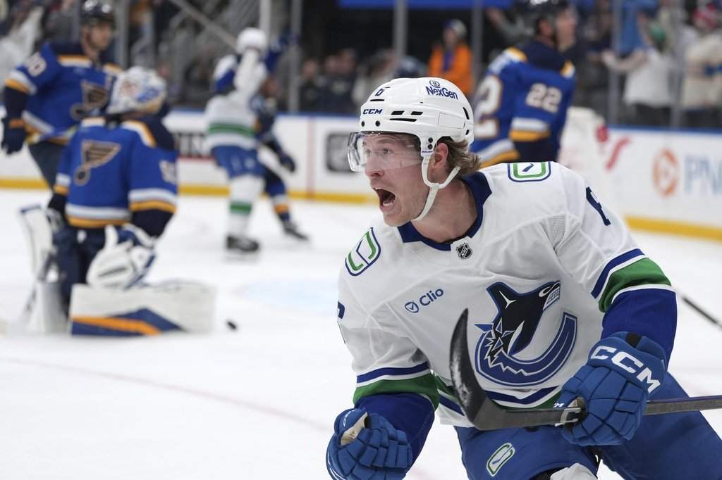 FILE - Vancouver Canucks' Brock Boeser, right, celebrates after scoring past St. Louis Blues goaltender Jordan Binnington, left, during the third period of an NHL hockey game, March 20, 2025, in St. Louis. 