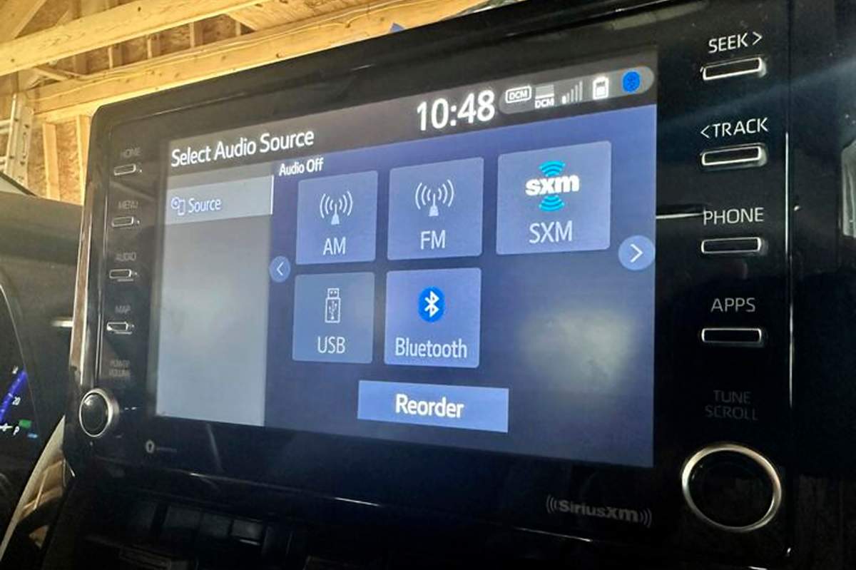 A display screen inside a vehicle shows various radio options