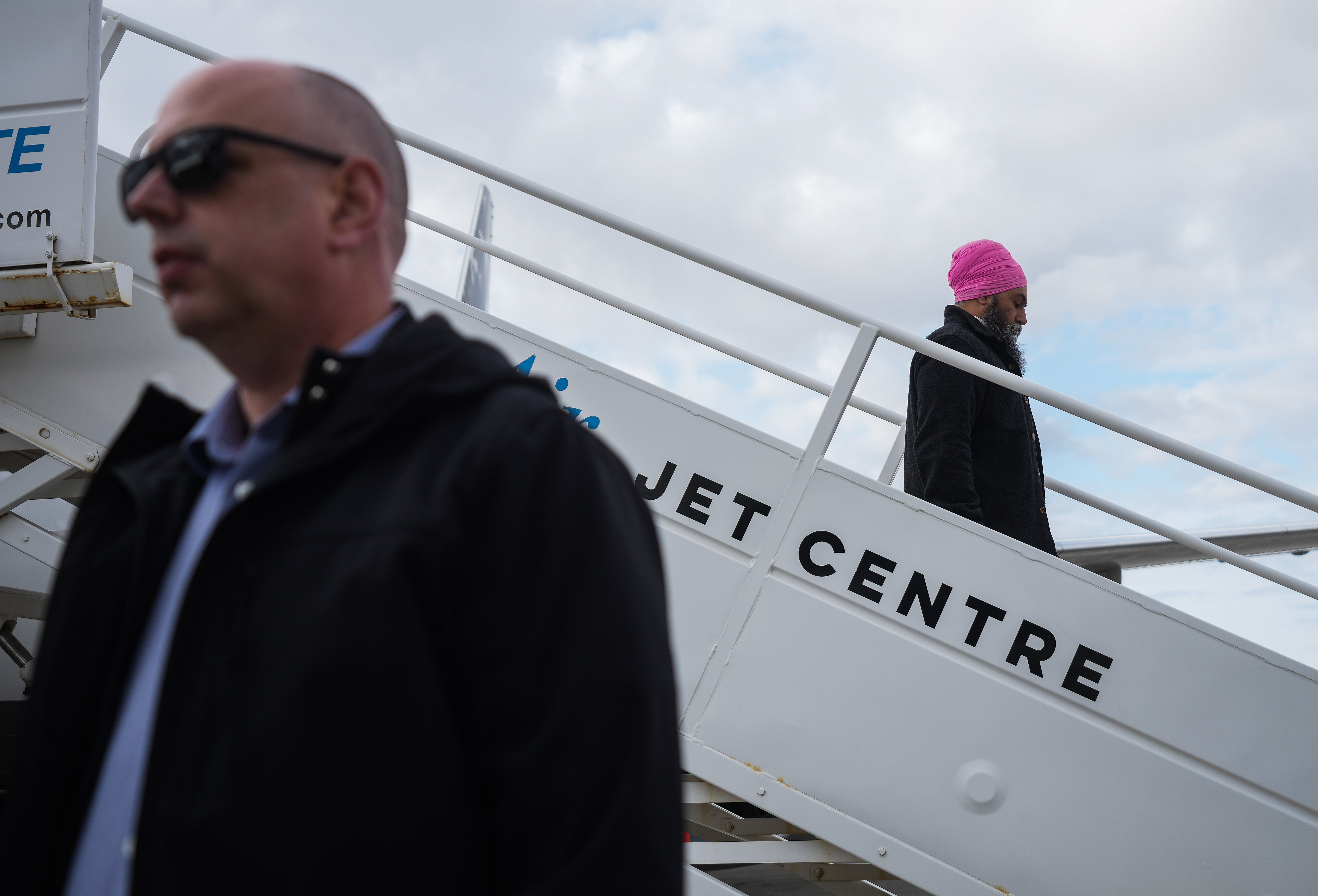 NDP Leader Jagmeet Singh steps off campaign plane as member of his RCMP security detail stands by in Winnipeg, April 23, 2025. THE CANADIAN PRESS/Darryl Dyck
