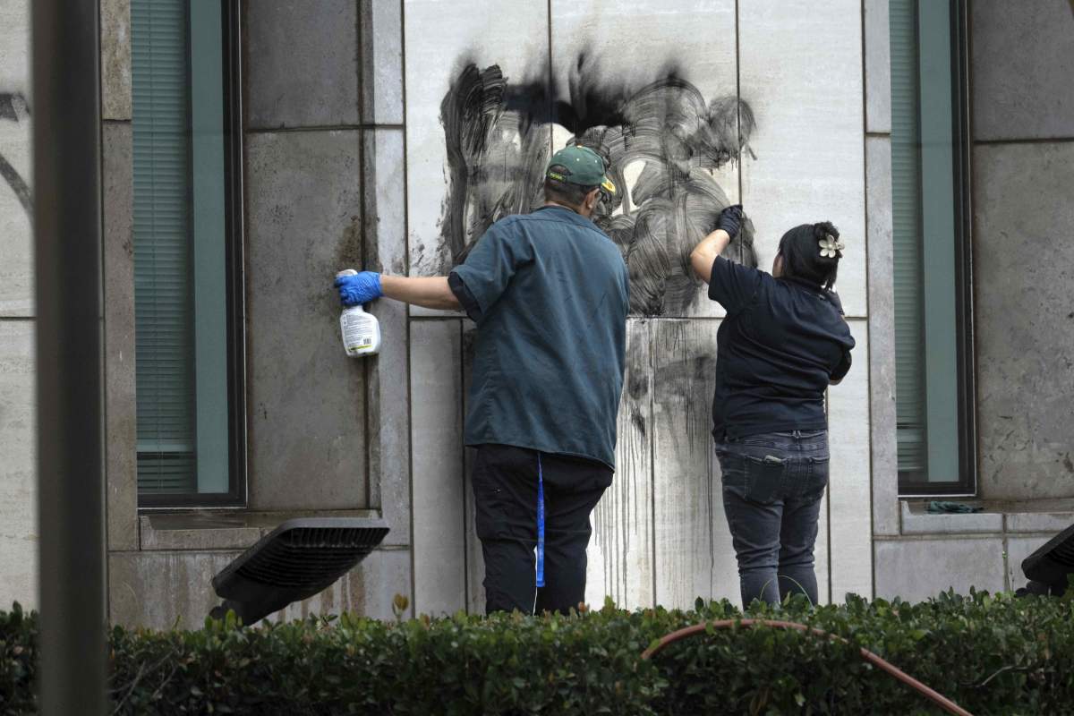Workers remove graffiti from the Ronald Reagan Federal Building and Courthouse in Santa Ana, Calif., Tuesday, June 10, 2025, after Monday’s protests against President Trump’s ICE raids resulted in violence. (Mindy Schauer/The Orange County Register via AP)