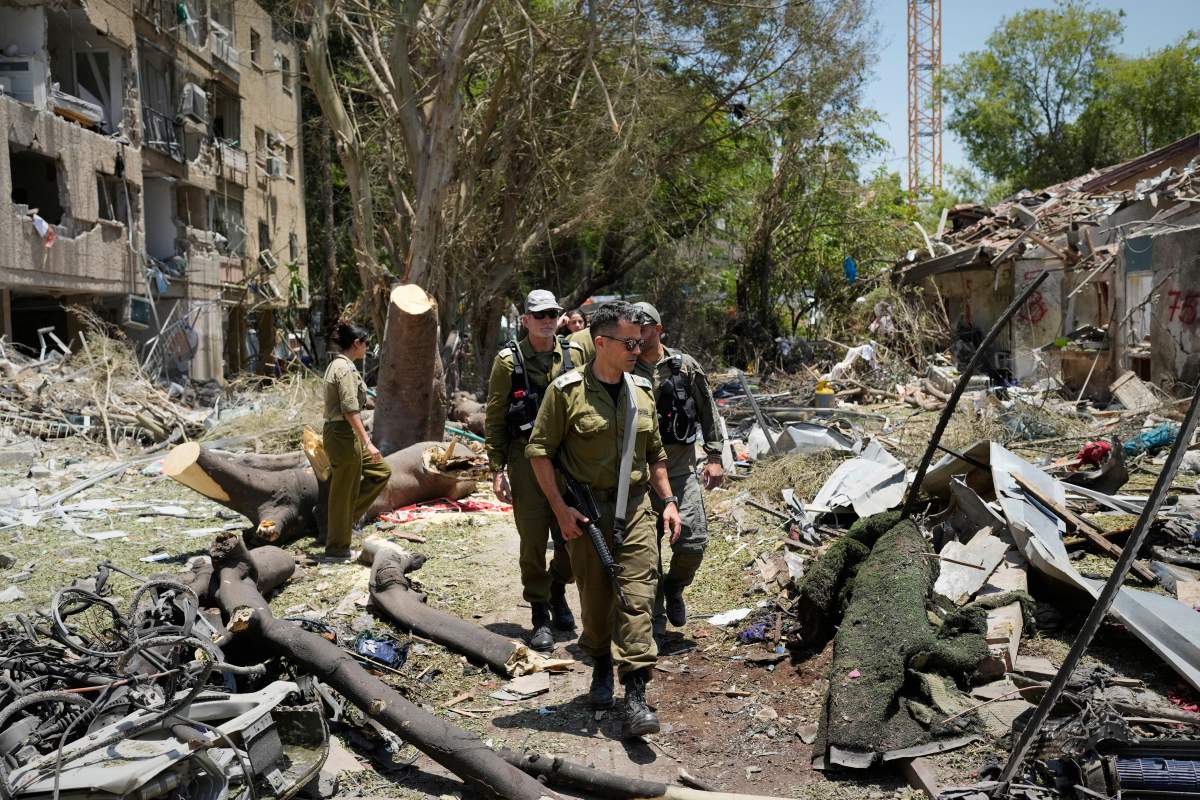 Israeli soldiers inspect the site struck by a direct missile strike launched from Iran in Tel Aviv, Israel, on Sunday, June 22, 2025.