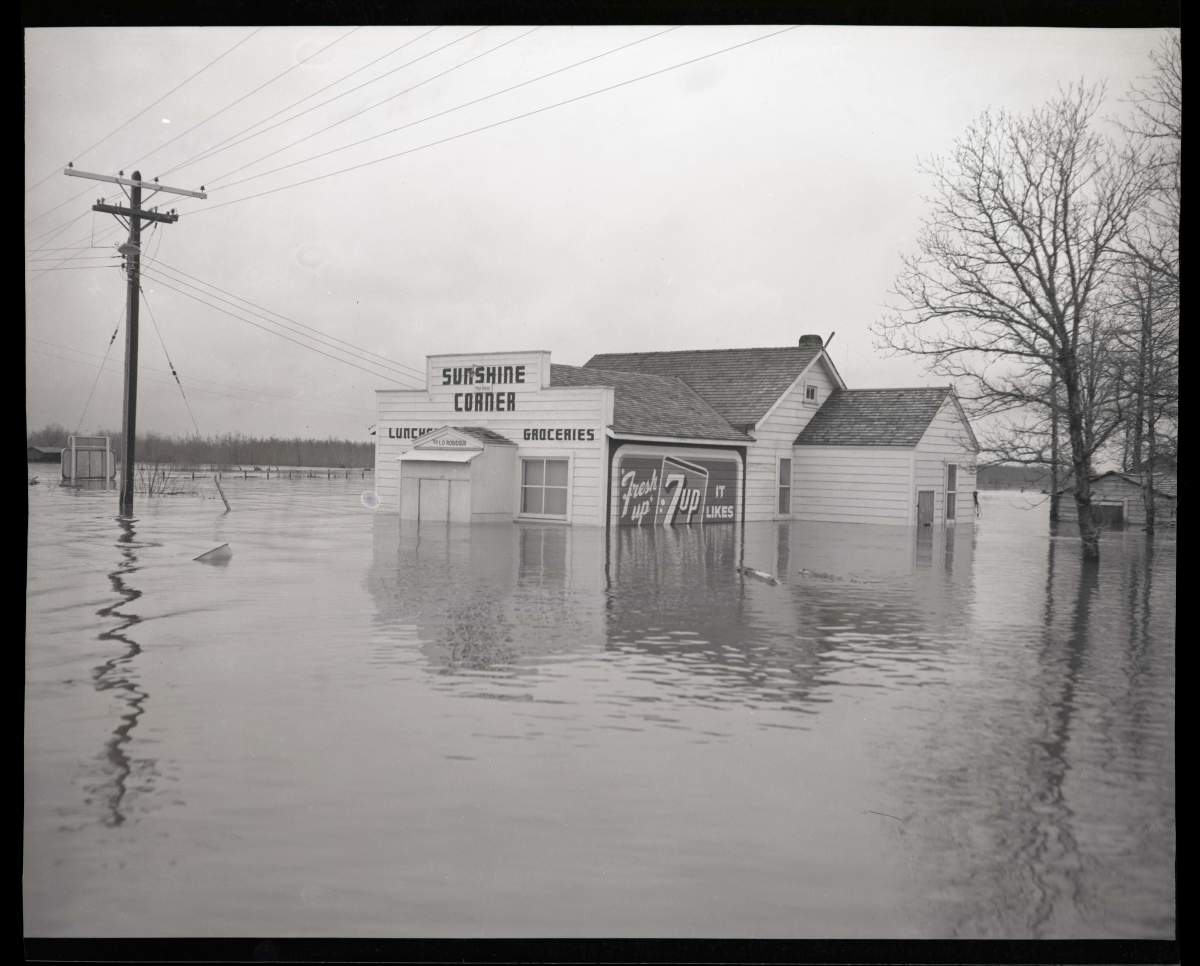 A cornerstore surrounded by floodwaters.